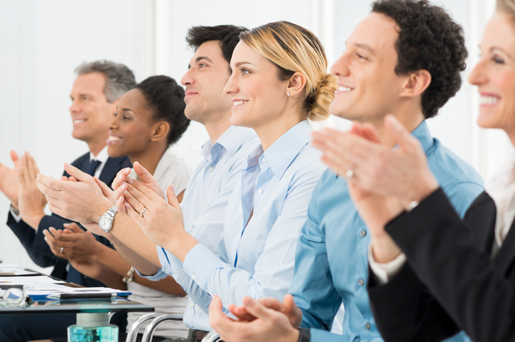 Happy Group Of Businesspeople Clapping In Boardroom